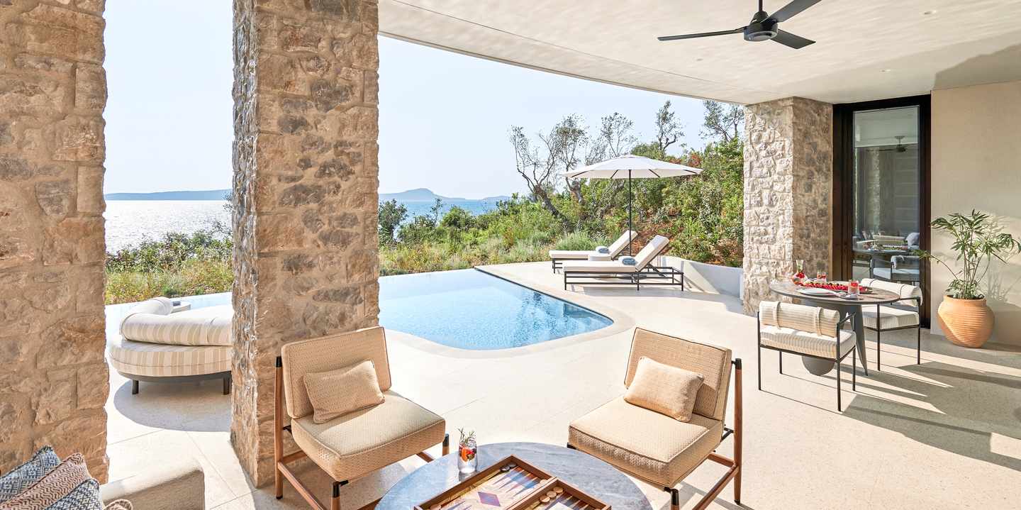 Blick aus potenziellem Zimmer mit Sitzgelegenheiten auf offene Terrasse mit eigenem Pool