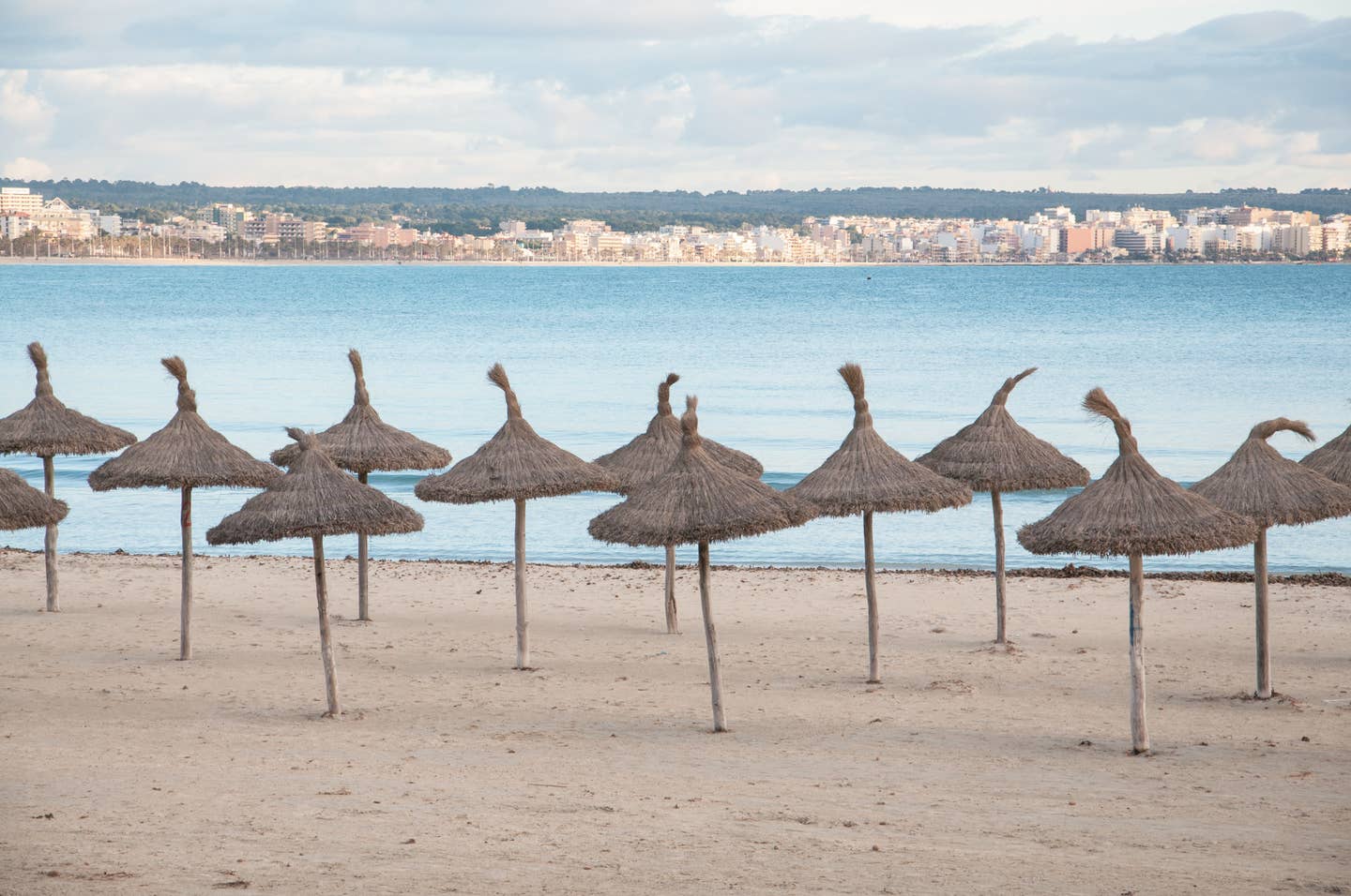 Can Pastilla Urlaub mit DERTOUR. Menschenleere Strand von Can Pastilla mit Sonnenschirmen