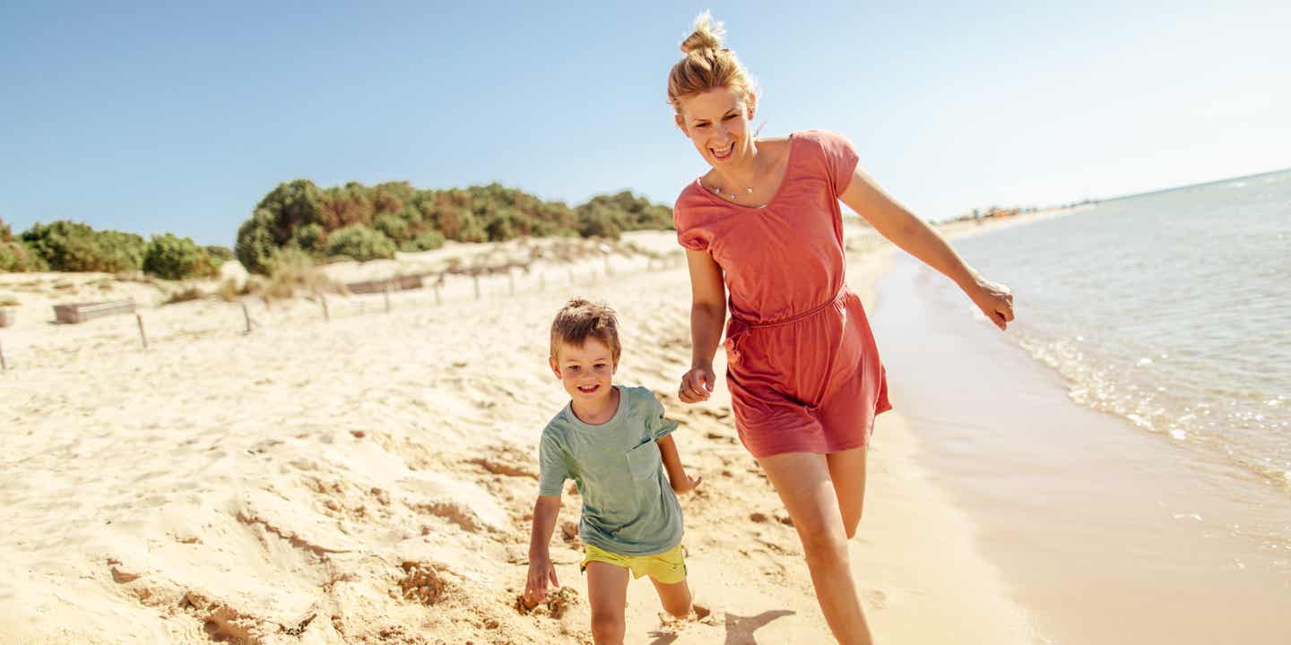 Familienurlaub in Italien: Mutter und Kind am Strand von Sardinien.