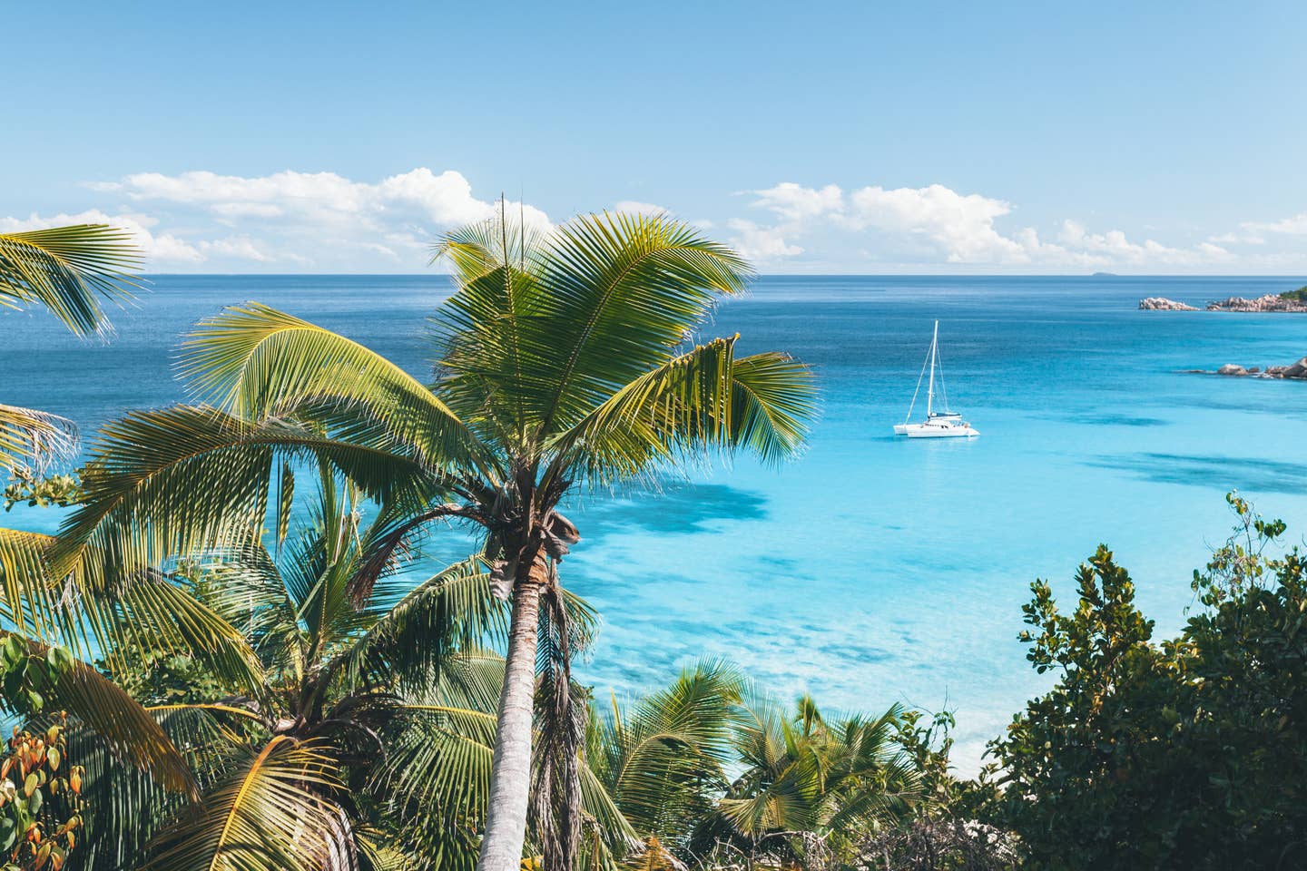 Rundreisen Seychellen: Segelboot in einer Bucht vor den Seychellen