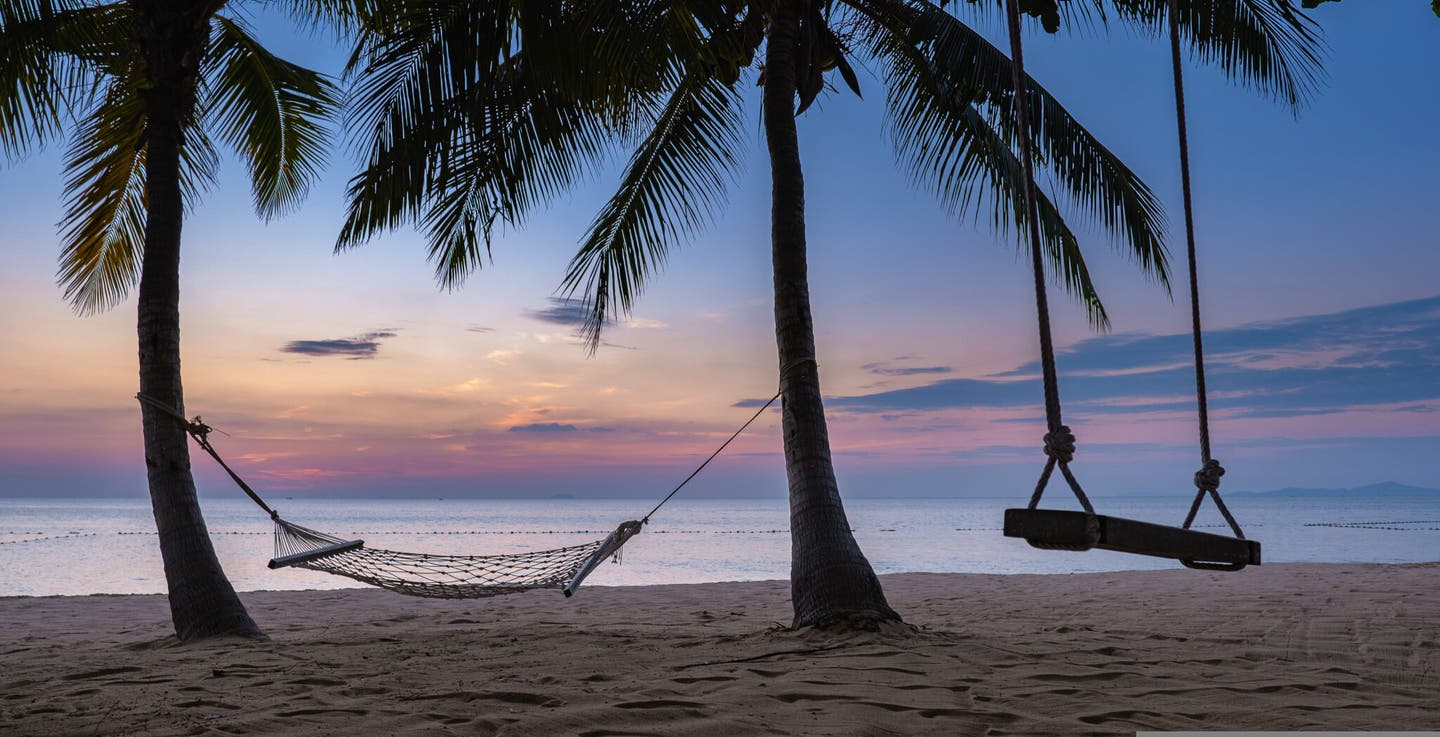 Hängematte unter Palmen am Jomtien Beach im Sonnenuntergang