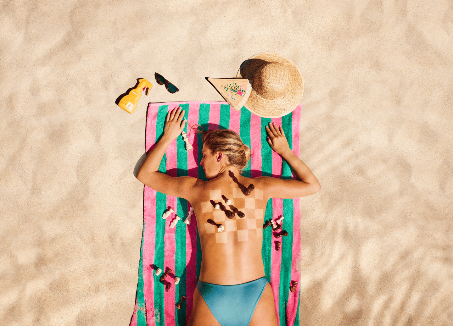 Frau liegt am Strand mit Schachbrettmuster auf dem Rücken