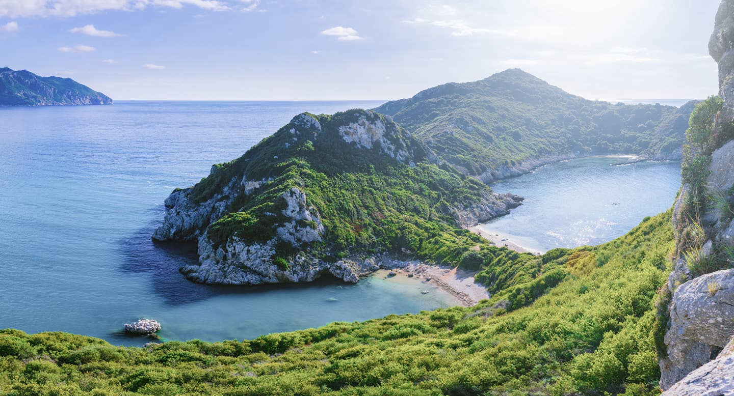 Urlaub an grünbewaldeten Buchten vor türkisblauem Meer