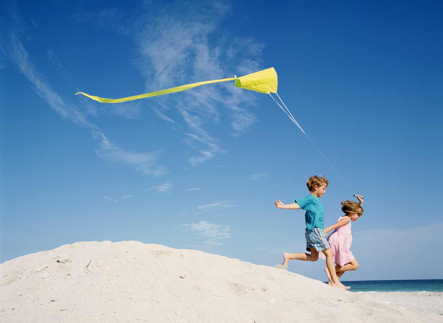 Spielende Kinder mit Winddrachen am Strand