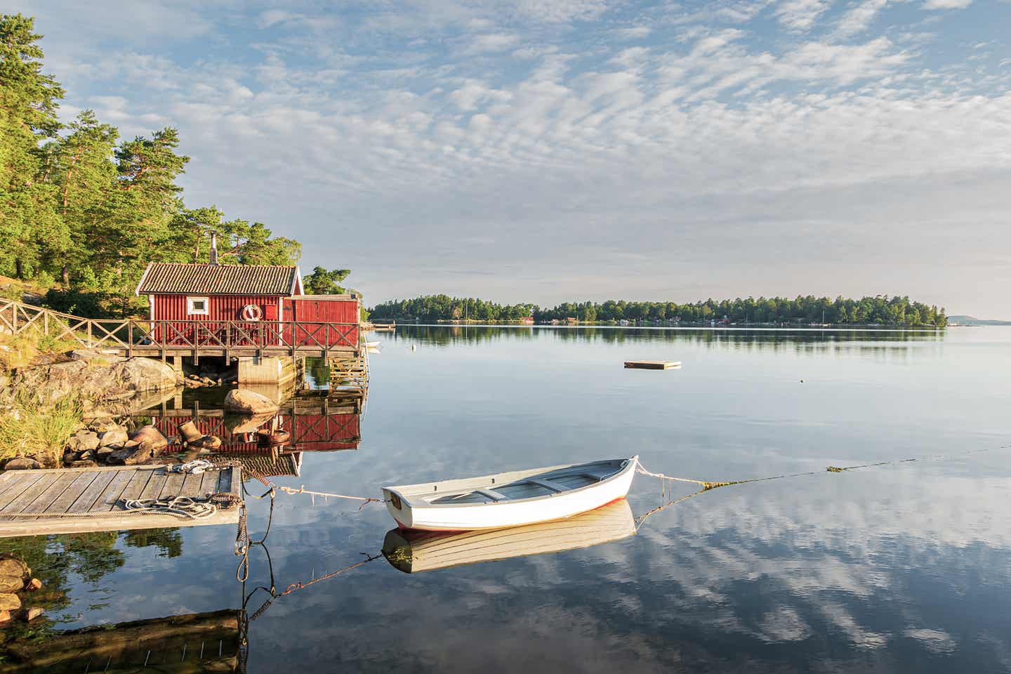 Schwedischer See mit weißem Boot und Steg Schwedischer See mit weißem Boot und Steg