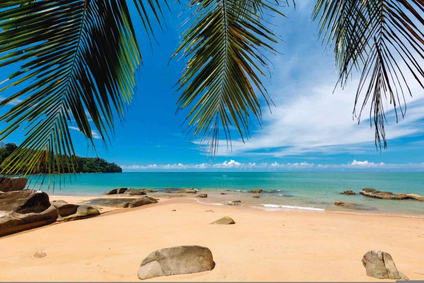 Der malerische Nang Thong Strand in Khao Lak mit kleinen Felsen und Palmen