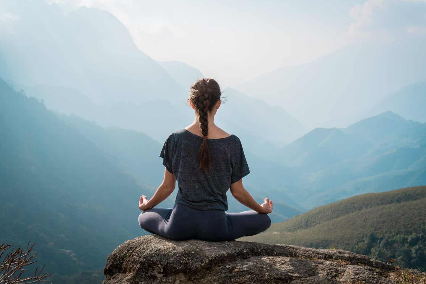 Frau macht Yoga auf einem Berg