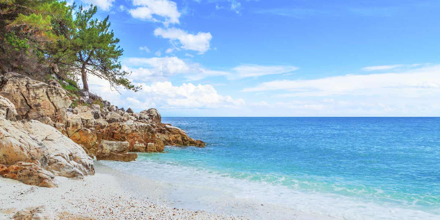 Ein feiner Kieselstrand auf Korfu mit flachem Einstieg und Blick auf das Blau des Meeres