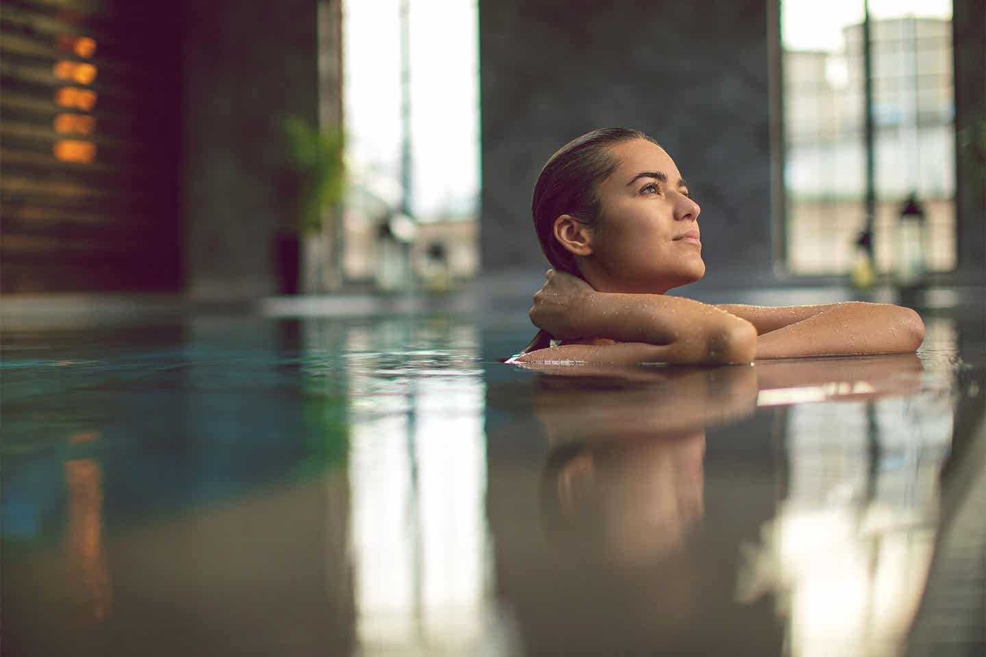 Wellnessurlaub Deutschland: Frau entspannt im Indoor Pool Ostsee