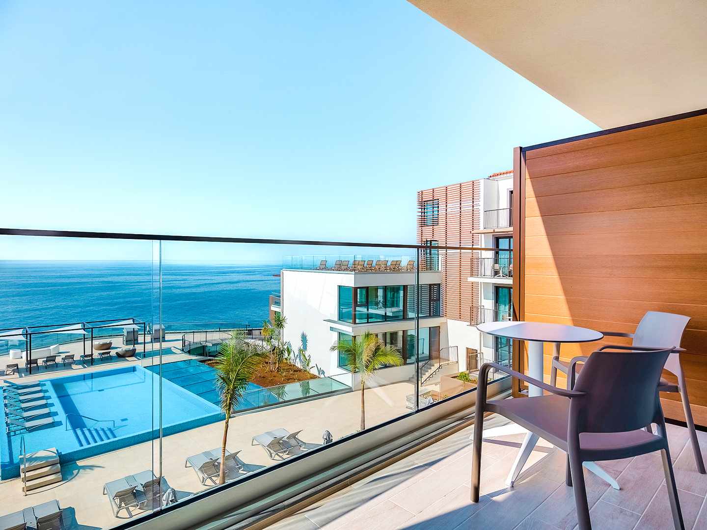 Schon der Ausblick entspannt Blick vom Balkon mit Sitzgelegenheit auf Pool und Meer
