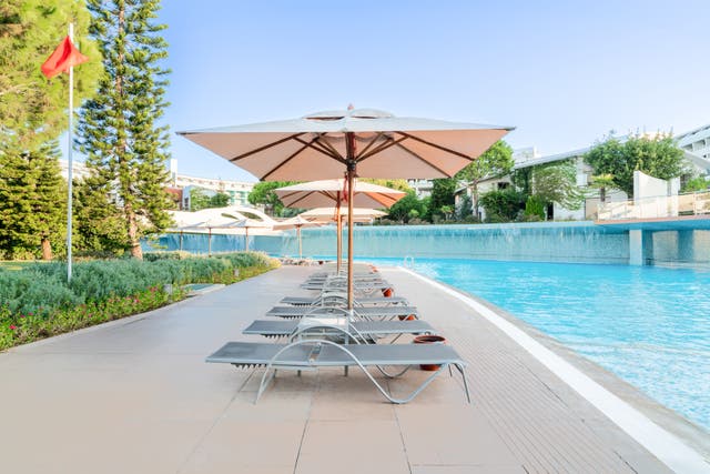 Poolbereich des Hotels mit Sonnenschirmen und Liegen