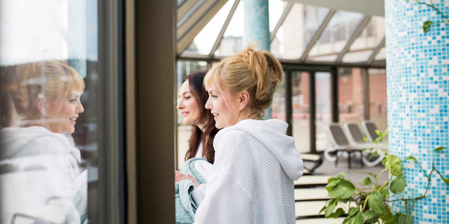 Zwei Freundinnen genießen während eines Wellnesswochenendes eine entspannte Pause im Spa-Bereich