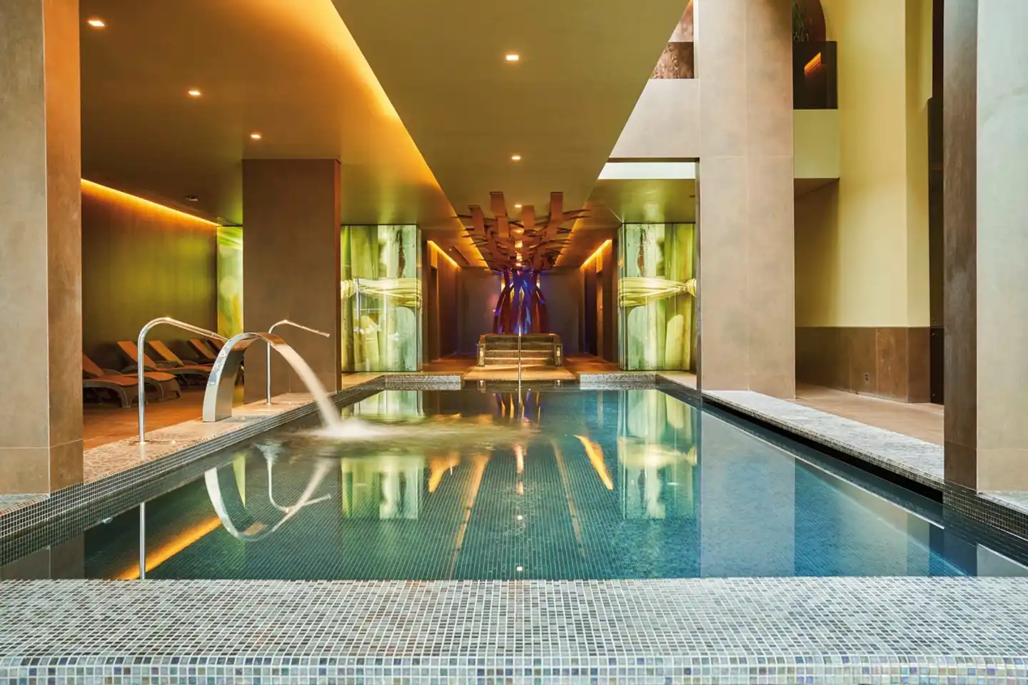 Der Indoorpool des Saccharum Resorts ist der ideale Ruheort. Indoorpool des Saccharum Resorts umgeben von kleinen Fliesen und warmer Beleuchtung