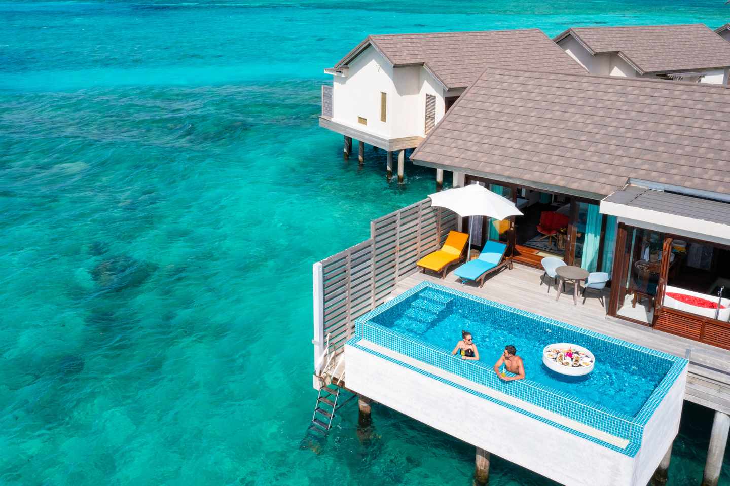 Atmosphere Kanifushi Maldives - Sunset Wasser Villa - Blick von oben - Paar badet im Pool und genießt den Urlaub Atmosphere Kanifushi Maldives - Sunset Wasser Villa - Blick von oben - Paar badet im Pool und genießt den Urlaub