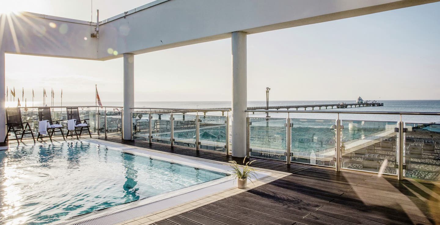 Ein Pool des aja Grömitz Hotels an der Ostsee mit Meerblick