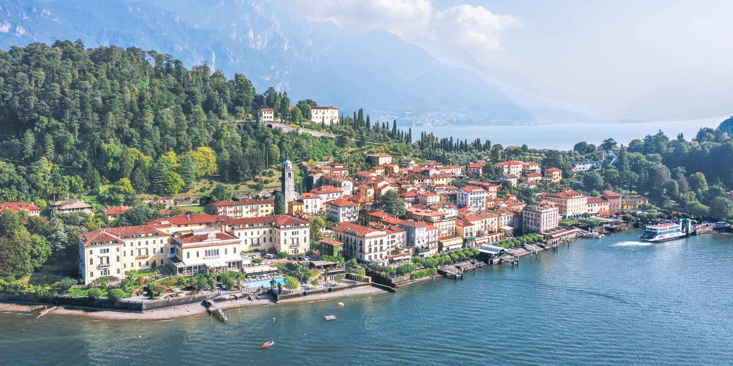 Blick auf die Altstadt von Bellagio am Comer See mit Bergen im Hintergrund zur Nachmittagssonne in der Lombardei
