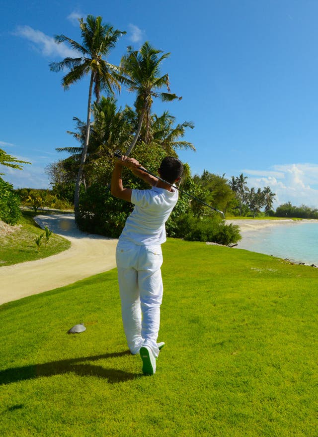 Golfplätze Malediven Mann schlägt einen Golfball ab
