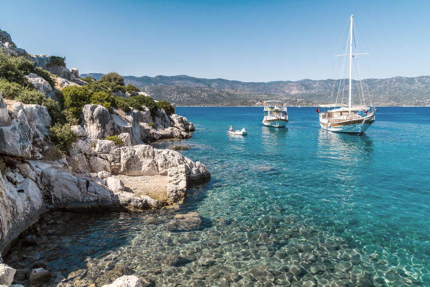 Türkei-Urlaub: zwei Boote in türkisfarbenem Wasser an der Küste