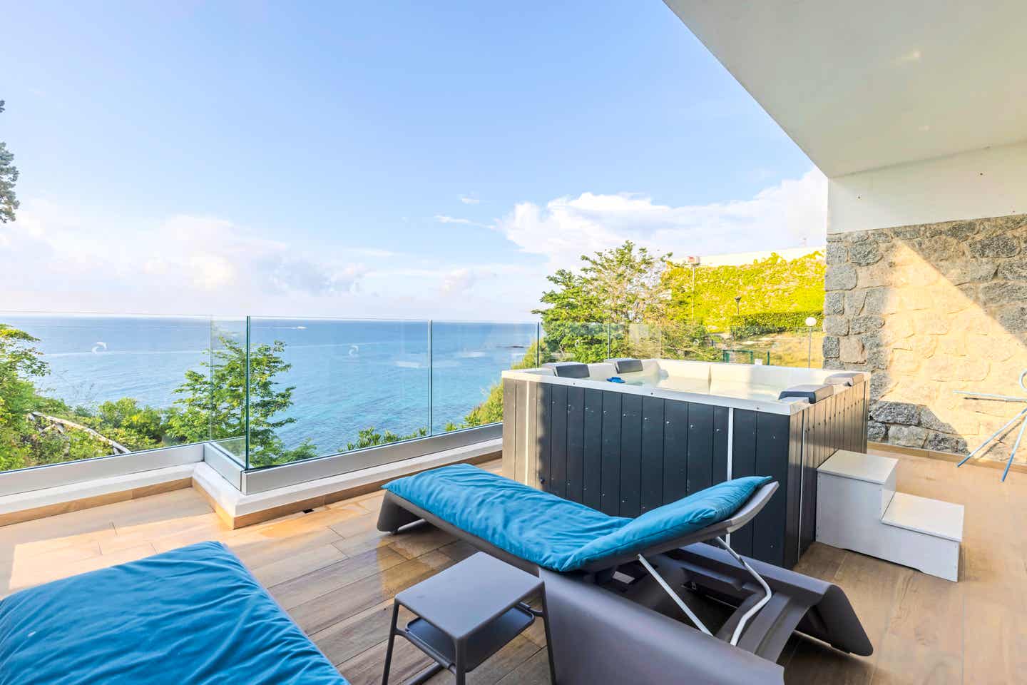 Liegestühle auf einem Balkon mit Meerblick Liegestühle auf einem Balkon mit Meerblick