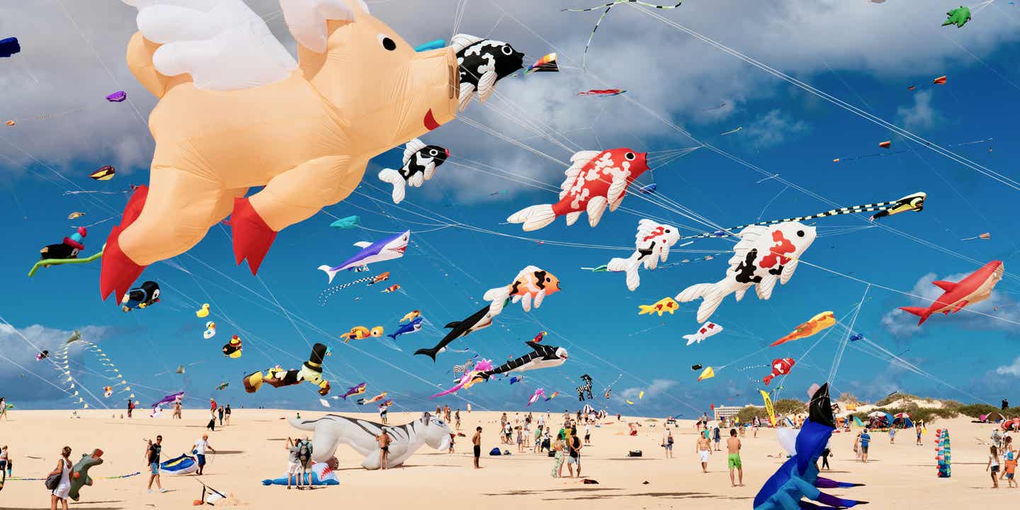 Kinder lassen Drachen steigen beim Kite Festival am Strand von Corralejo auf Fuerteventura