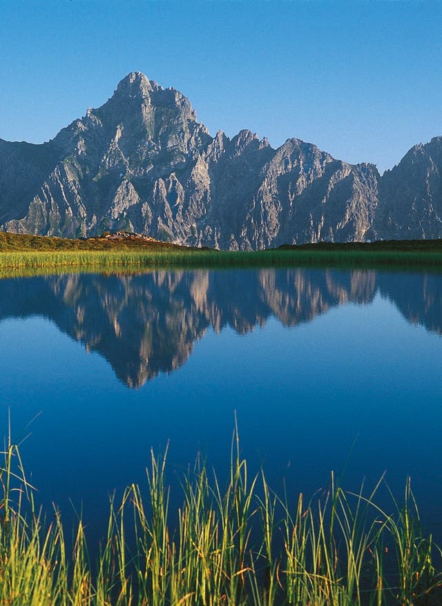 Jetzt buchen Berge hinter einem See in Vorarlberg Österreich