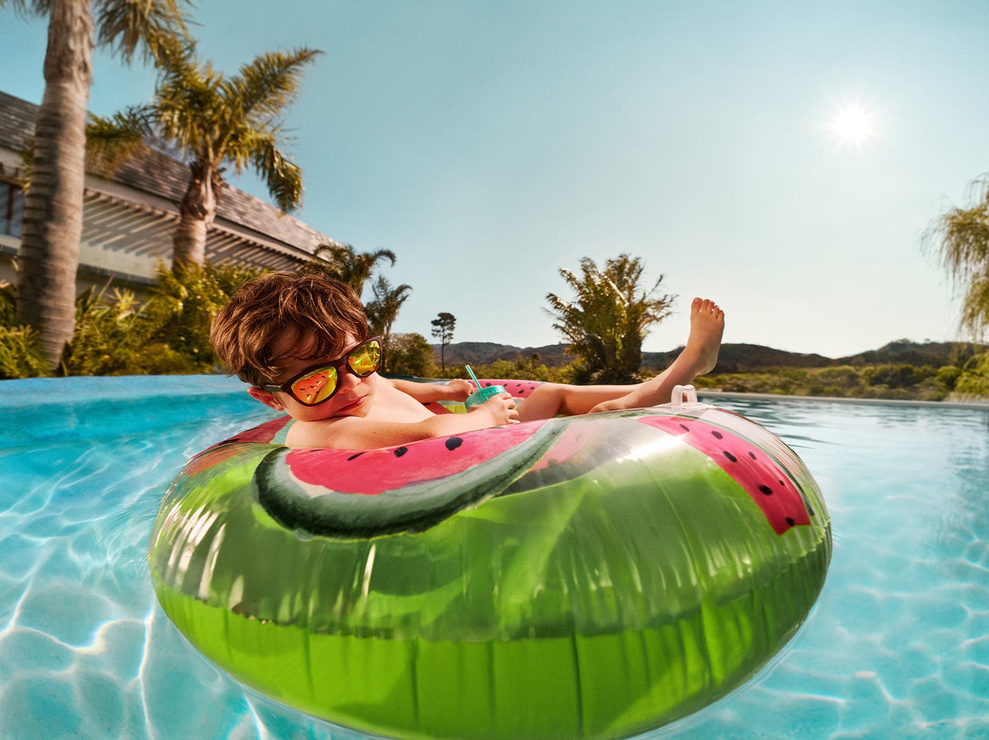 BUCHT MIT RABATTMACHERN - Junge relaxt in einem großen Schwimmreifen im Pool