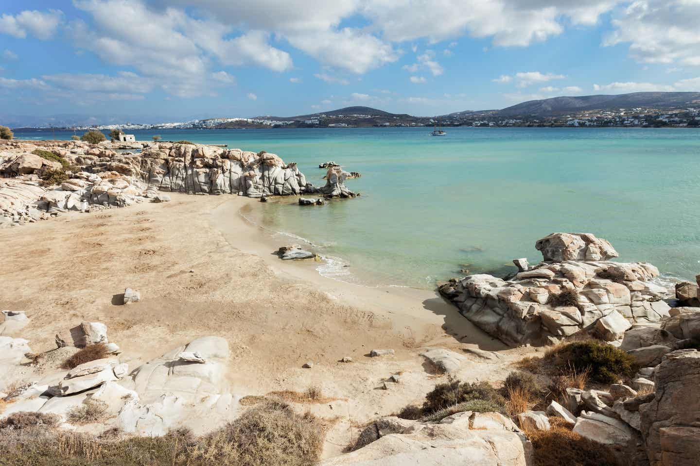 Paros Urlaub mit DERTOUR. Menschenleerer Strand von Kolimbithres auf Paros eingerahmt von Felsen