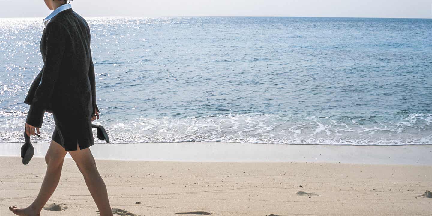 Businesswoman blickt in die Weite am Strand