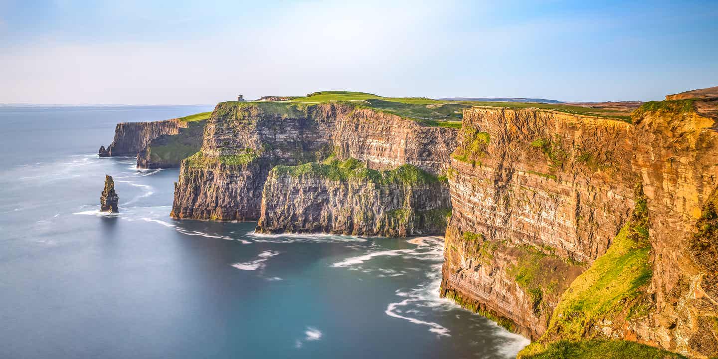 Cliffs of Moher auf eine Roadtrip durch Irland bei Sonnenuntergang mit Blick auf die steilen Klippen und den Atlantik 