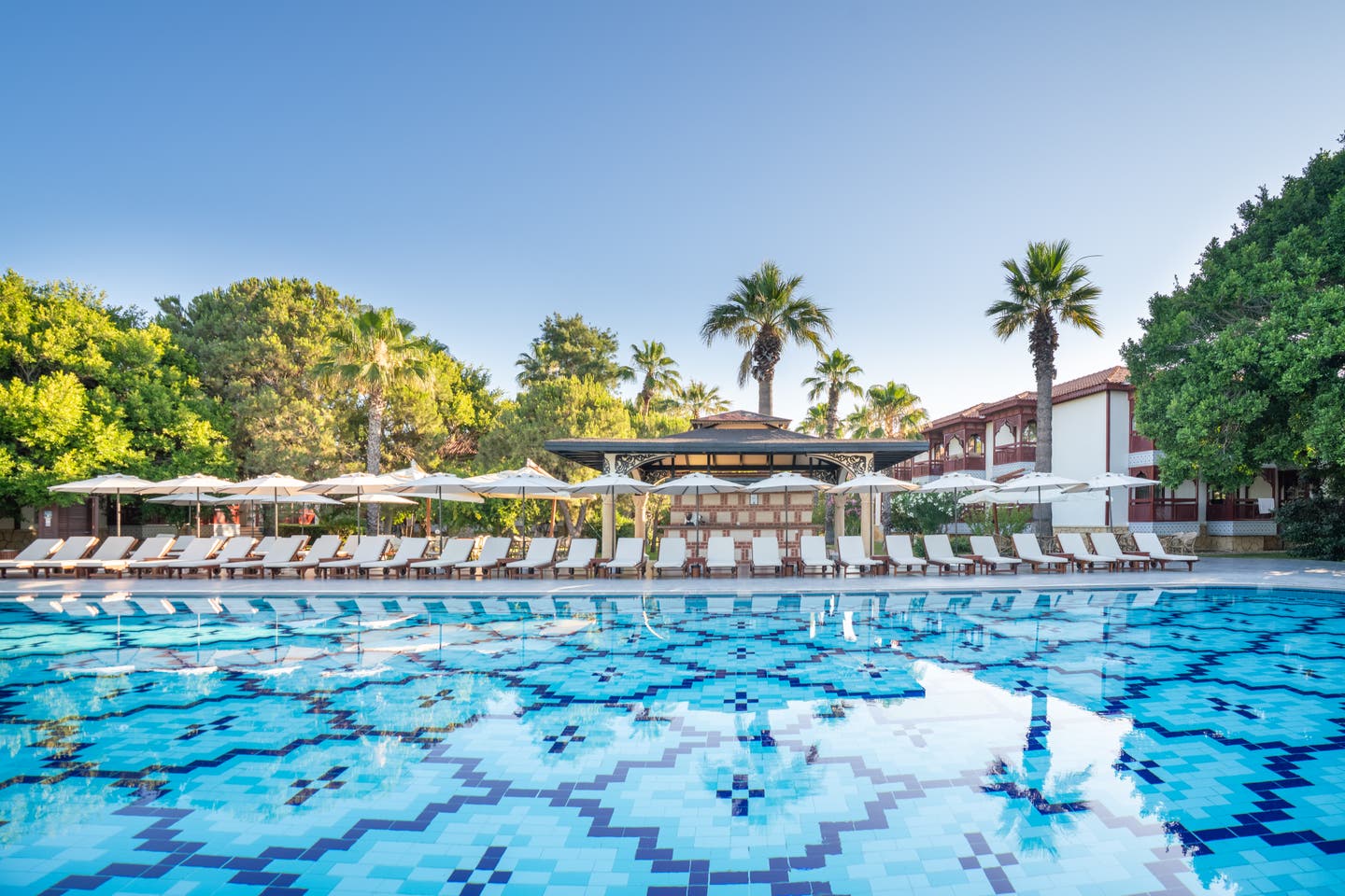 Sonnenliegen und -schirme am Hotelpool