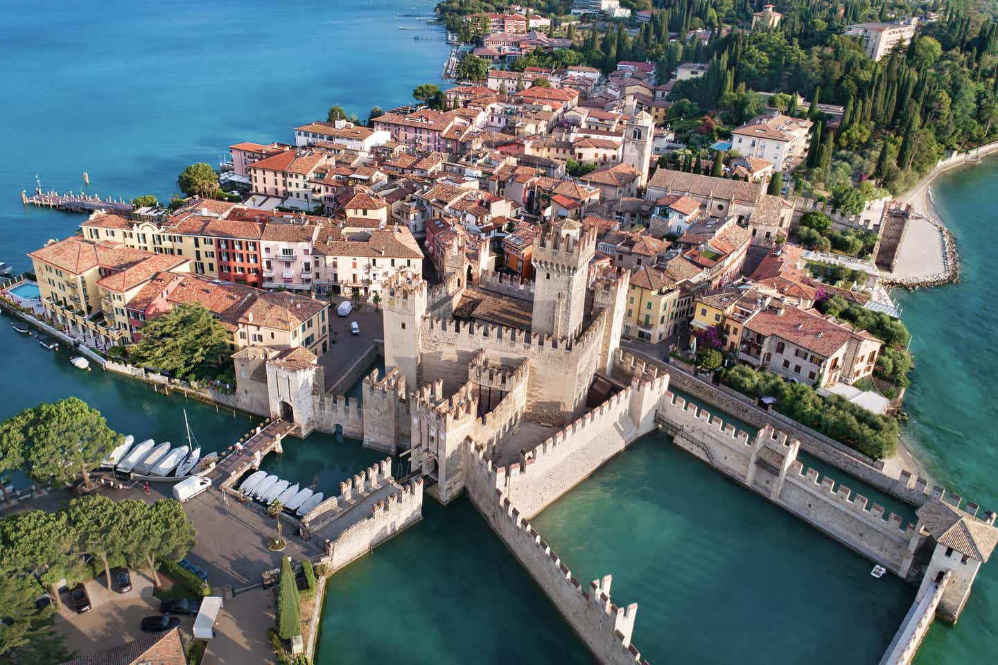 Gardasee Urlaub mit DERTOUR. Luftaufnahme der Stadt Sirmione mit ihrem kleinen Hafen am Gardasee