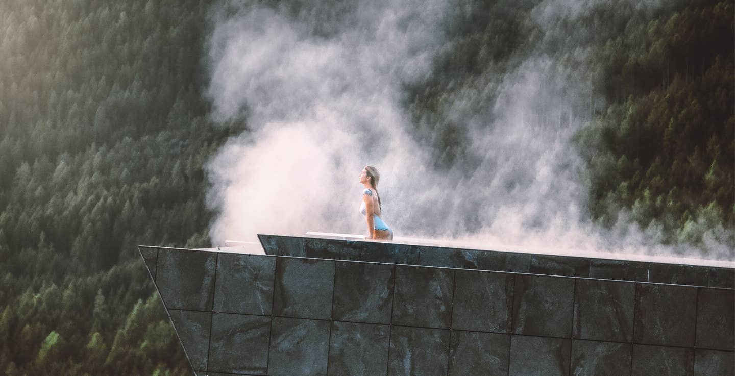 Frau im Pool vor Bergkulisse im Wellnessurlaub in Südtirol