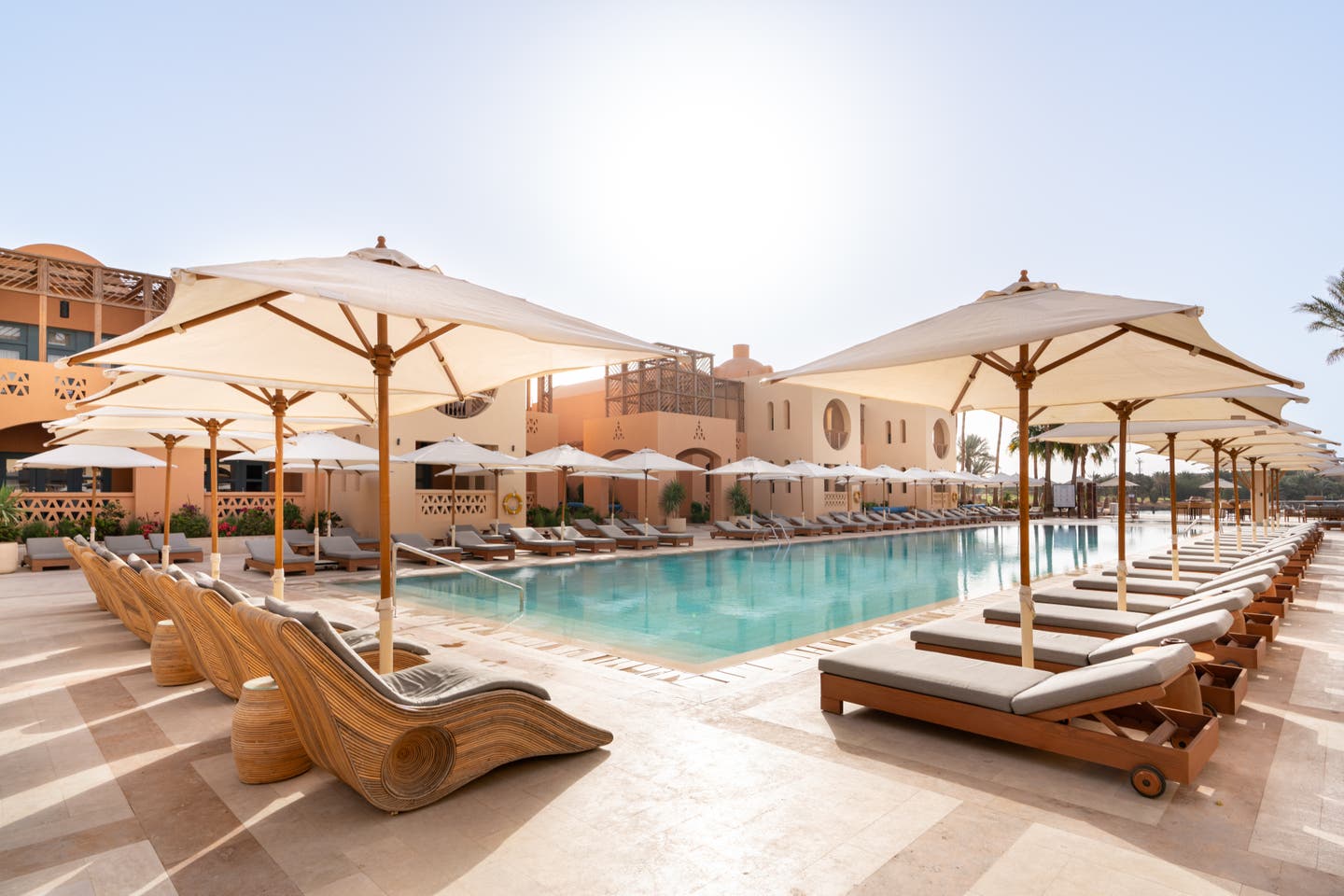 Poolbereich des Hotels mit Sonnenschirmen und Liegen