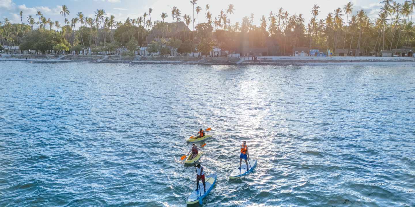 Blick auf Stand-up-Paddler vor der Küste eines ananea Hotels in Afrika