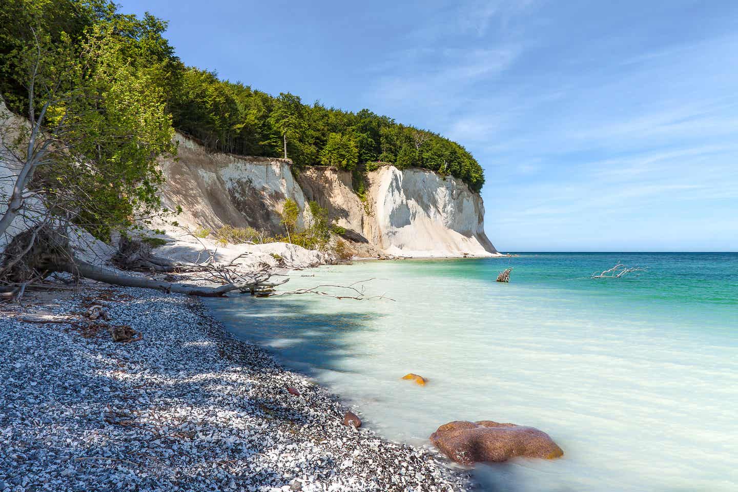 Kreidefelsen auf der Insel Rügen an der Ostsee, mit türkisfarbenem Wasser und grünem Küstenwald