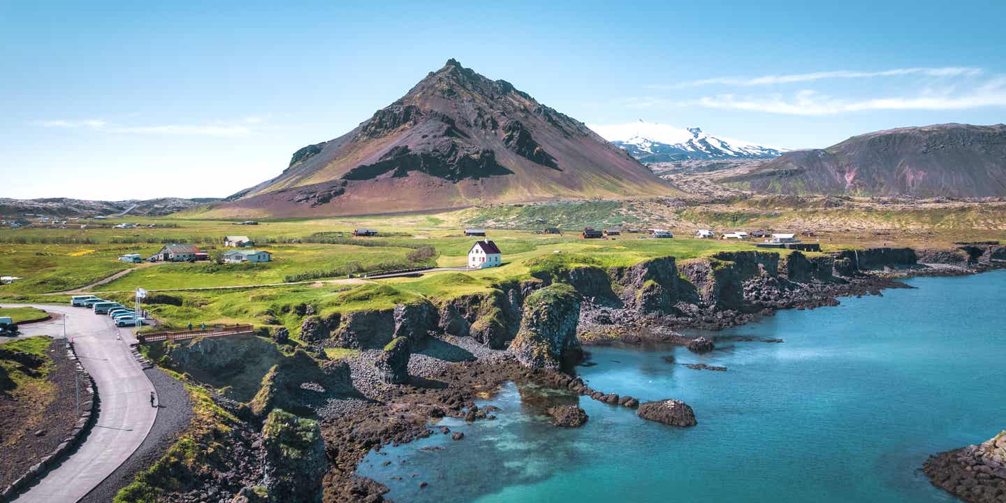 Blick auf ein Fischerdorf an einem See mit einem Berg im Hintergrund