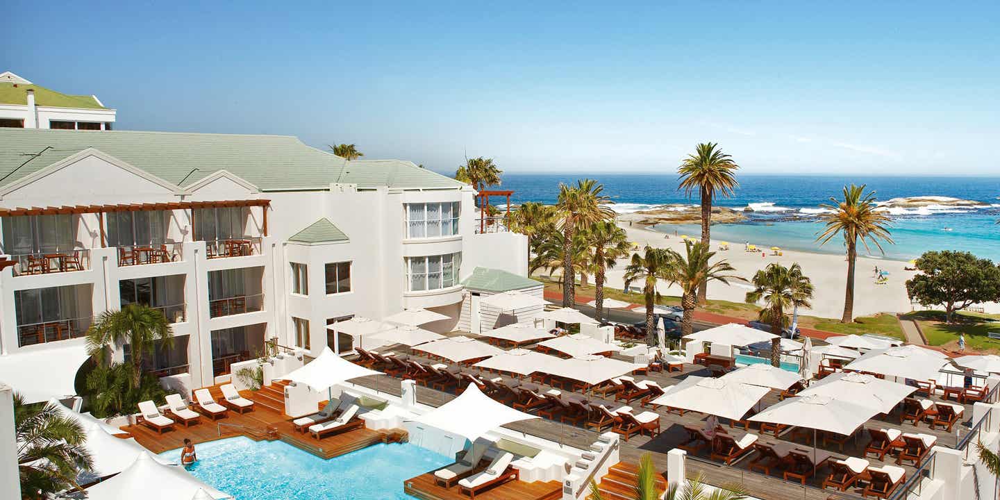 Poolgenuss mit Meerblick an der Camps Bay Beach im The Bay Hotel in Kapstadt The Bay Hotel in Kapstadt mit Poolterrasse, Sonnenliegen und direktem Blick auf den Strand von Camps Bay und den Atlantik