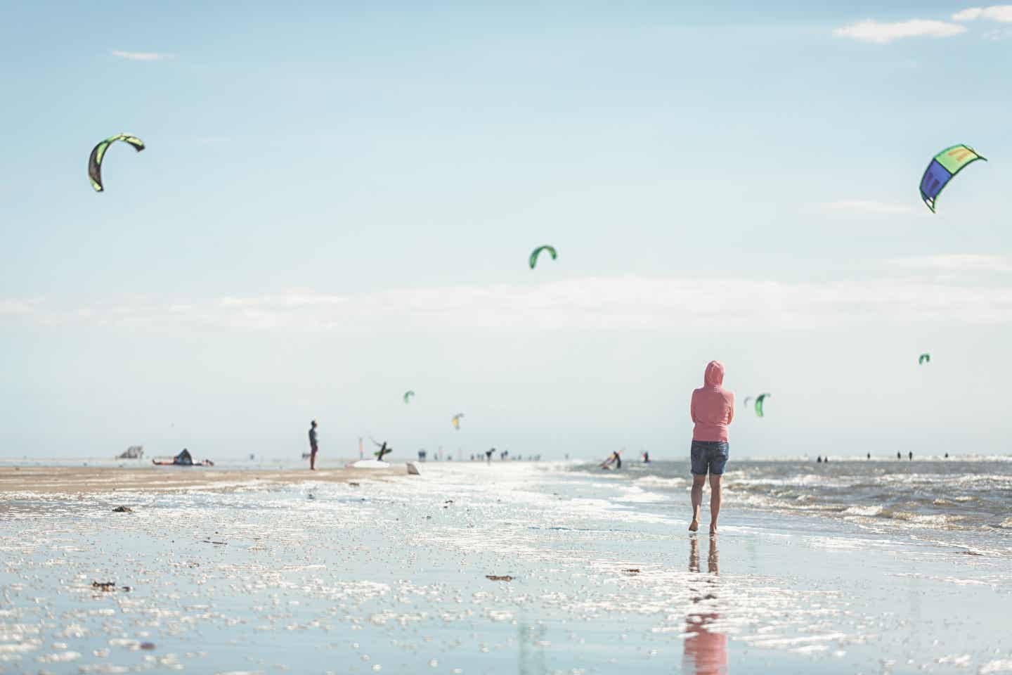 Sylt Urlaub mit DERTOUR. Menschen lassen Drachen am Strand von Sankt-Peter-Ording auf Sylt steigen