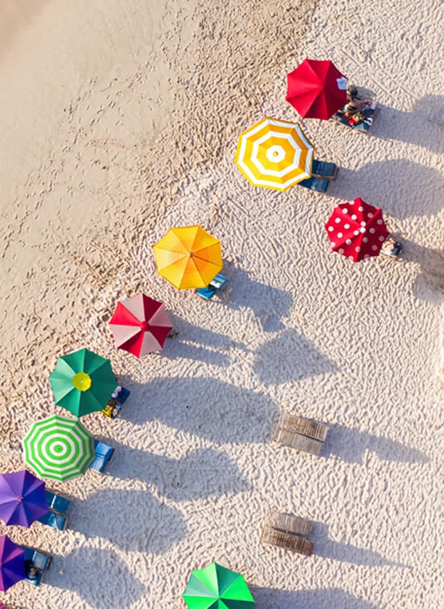 DEALS DEALS: Strand von oben mit bunten Sonnenschirmen