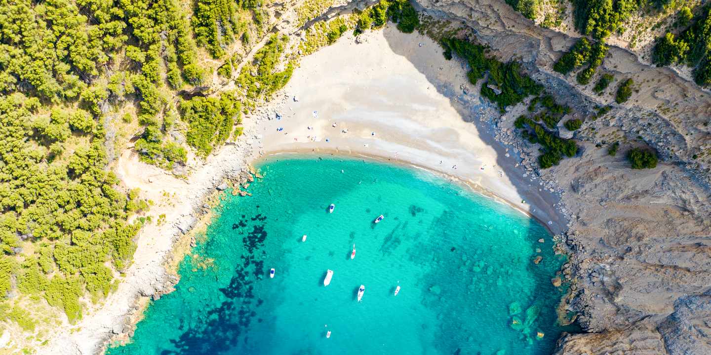 Es Coll Baix auf Mallorca aus der Luft mit Sandstrand, türkisblauem Wasser und umgeben von steilen, bewaldeten Felsen