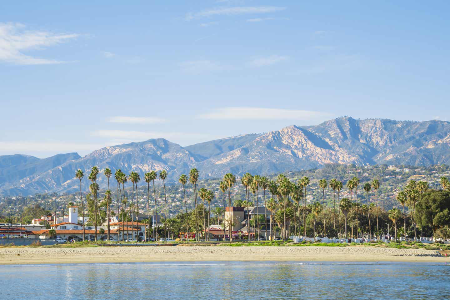 Blick auf die palmengesäumte Küste des East Beach in Santa Barbara mit den Santa Ynez Mountains im Hintergrund