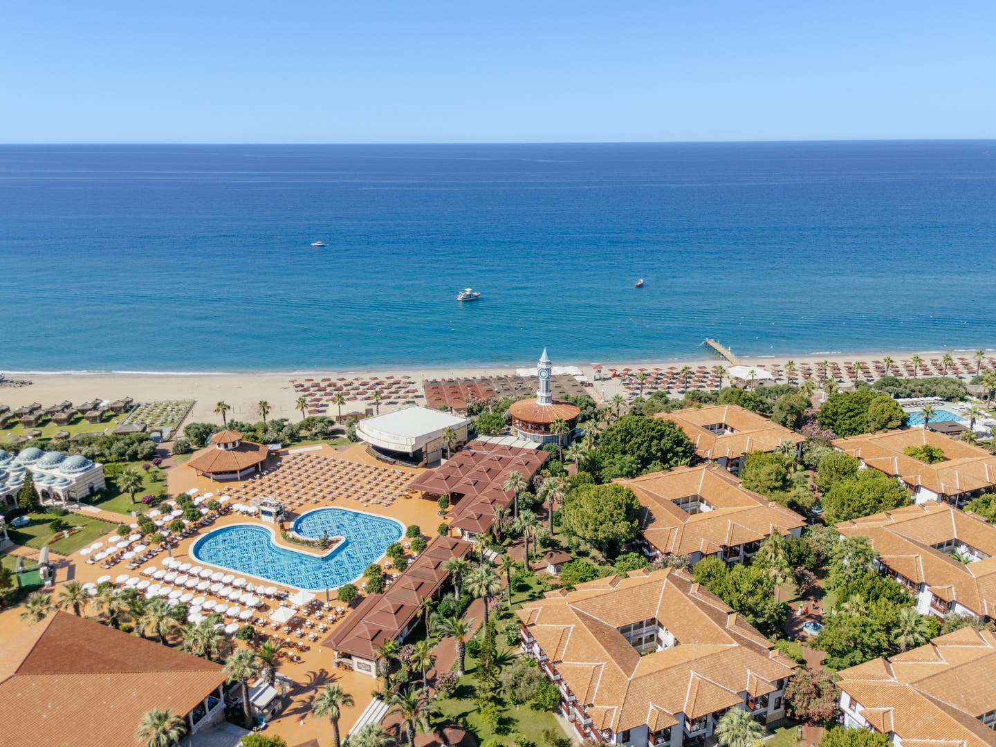 Zentraler Pool, Unterkünfte, Strand und Meer in einer Lufaufnahme