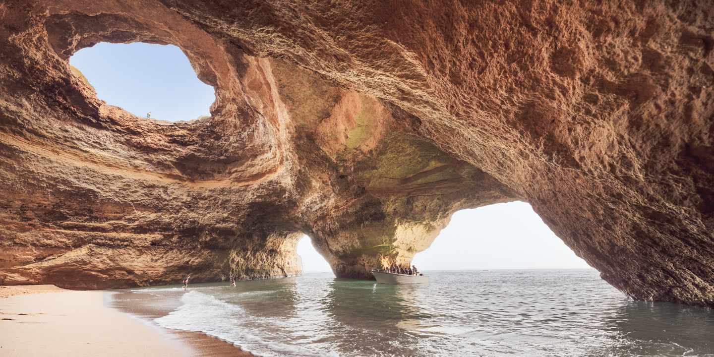 Blick aus der Benagil-Höhle an der Algarve mit Sandstrand, Meerwasser und natürlicher Felsöffnung