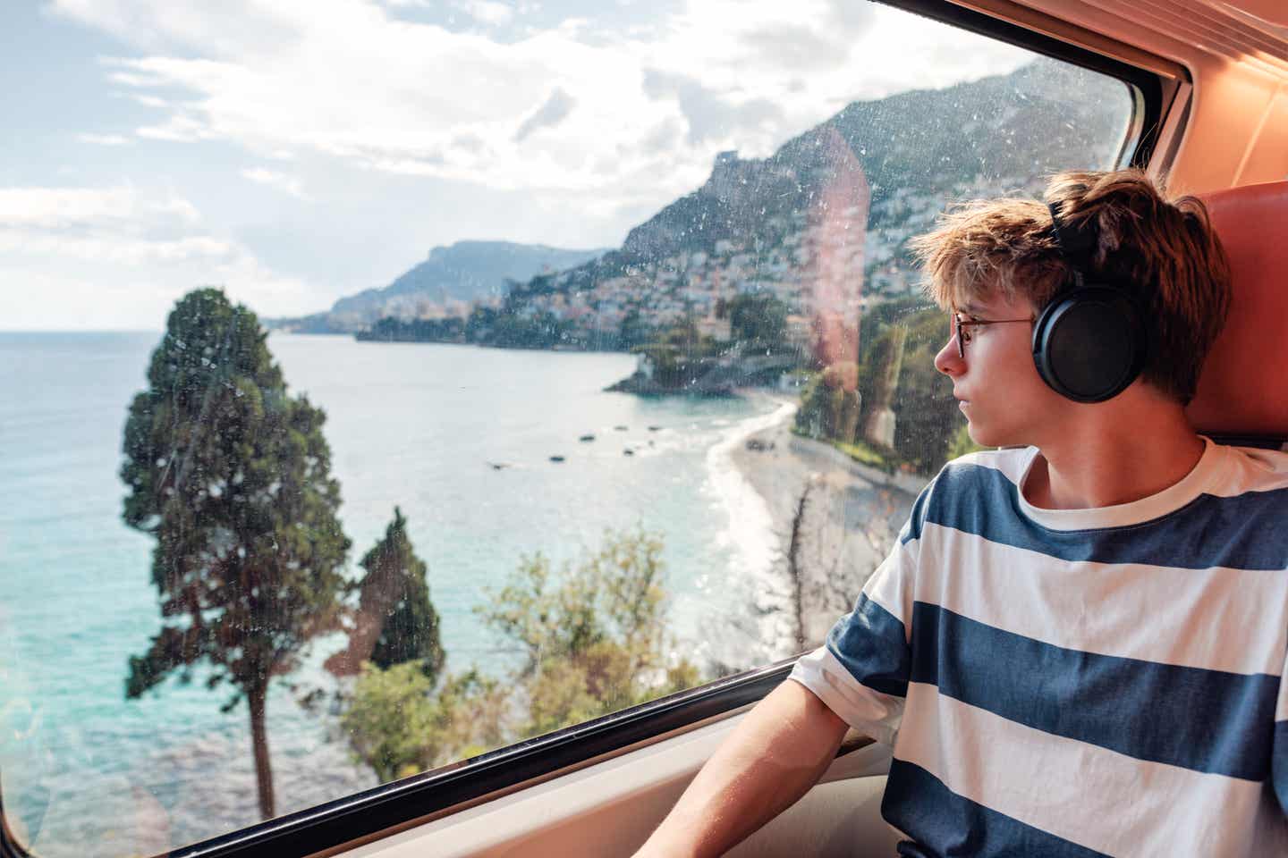 Städtereise mit der Bahn: Teenagerjunge im Zug an der Côte d’Azur