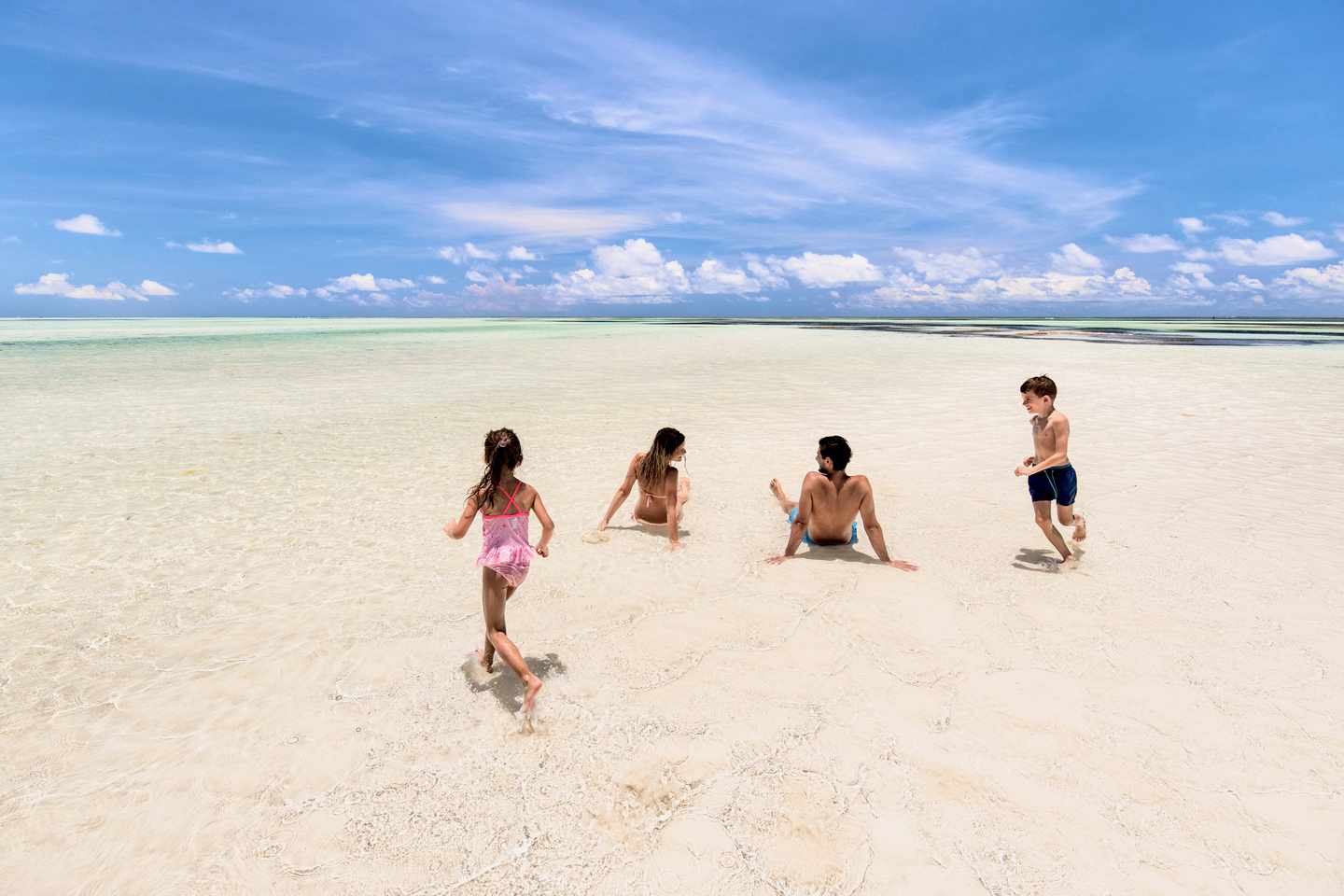 Eine Familie spielt im Wasser an einem Strand von Sansibar