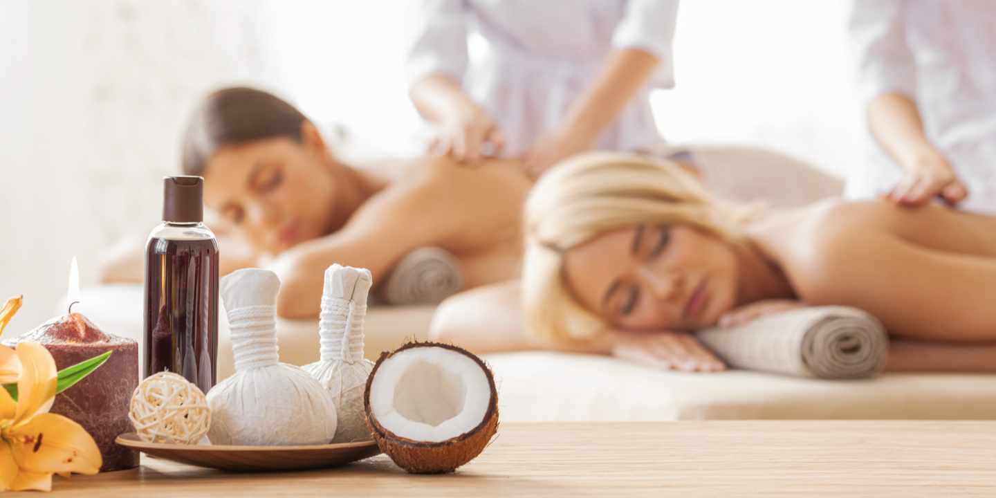 Zwei Freundinnen genießen während eines Freundinnen Wellnesswochenendes eine entspannende Rückenmassage im Spa