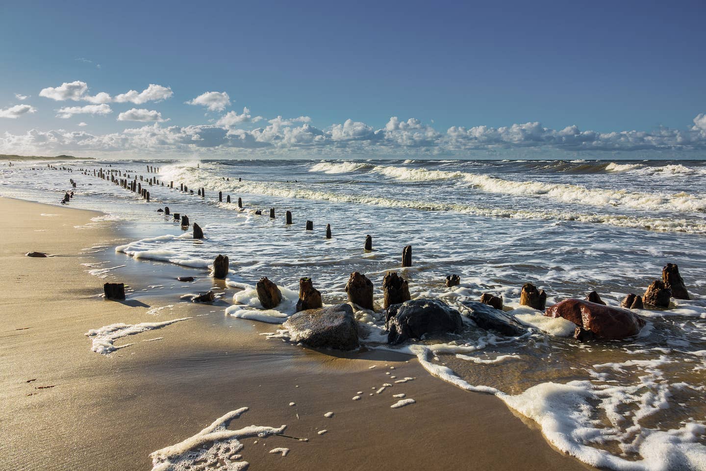 Kühlungsborn Urlaub mit DERTOUR. Sonniger Tag am Strand bei Kühlungsborn - Buhnen in den heranrollenden Wellen