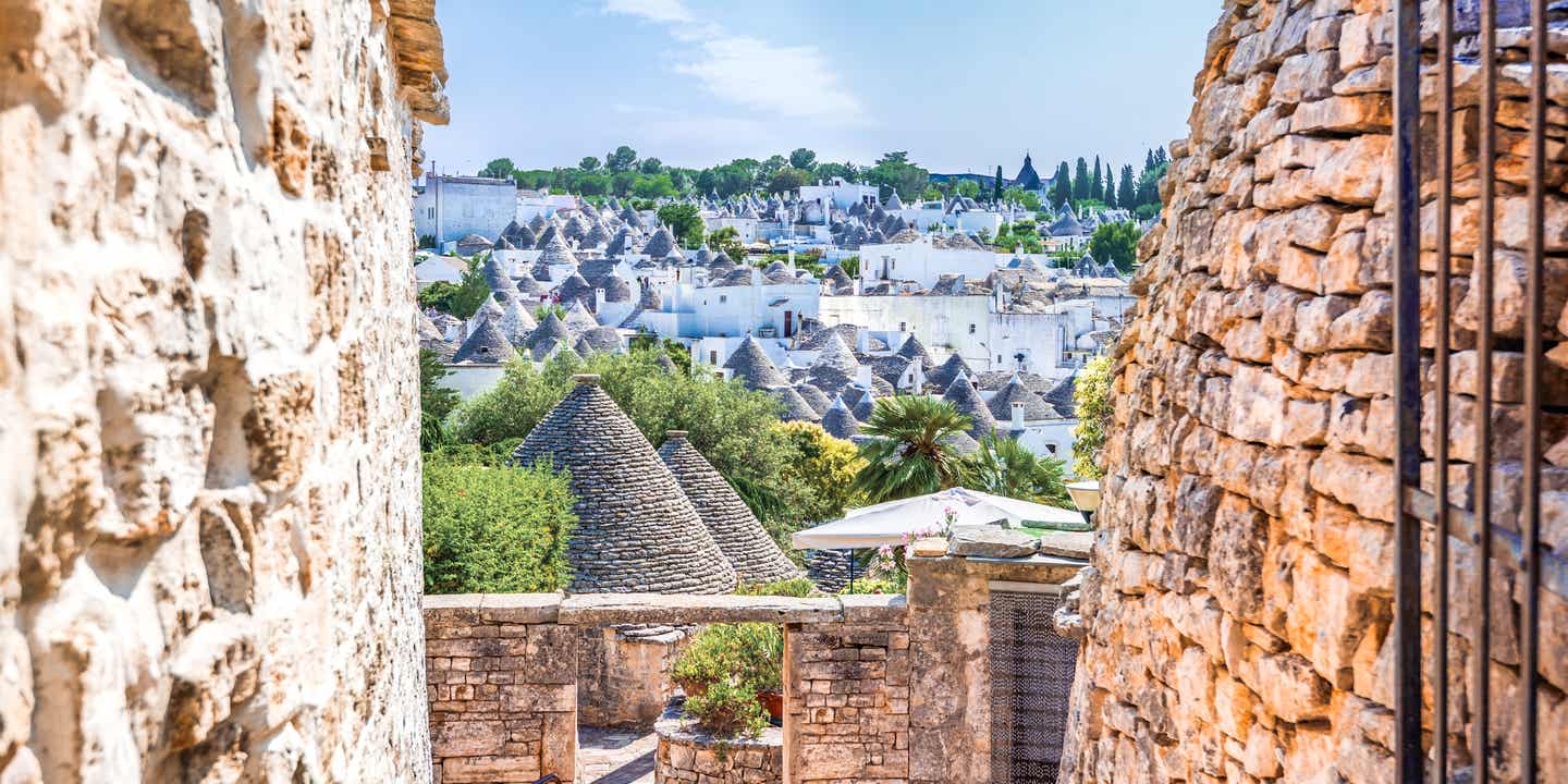 Blick durch eine enge Gasse auf die Trullihäuser von Alberobello 