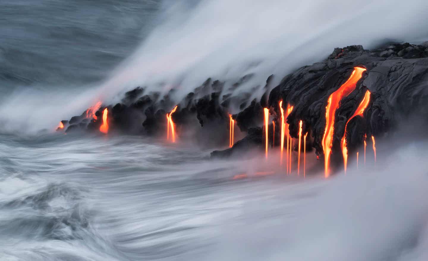 Glühende Lava strömt aus einem Vulkan ins Meer