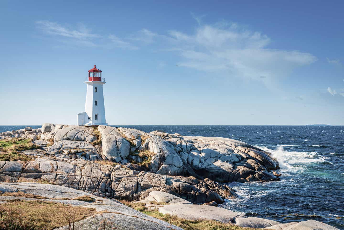 Blick auf den Leuchtturm Peggy's Cove an der Küste von Nova Scotia in Kanada; im Hintergrund das blaue Meer